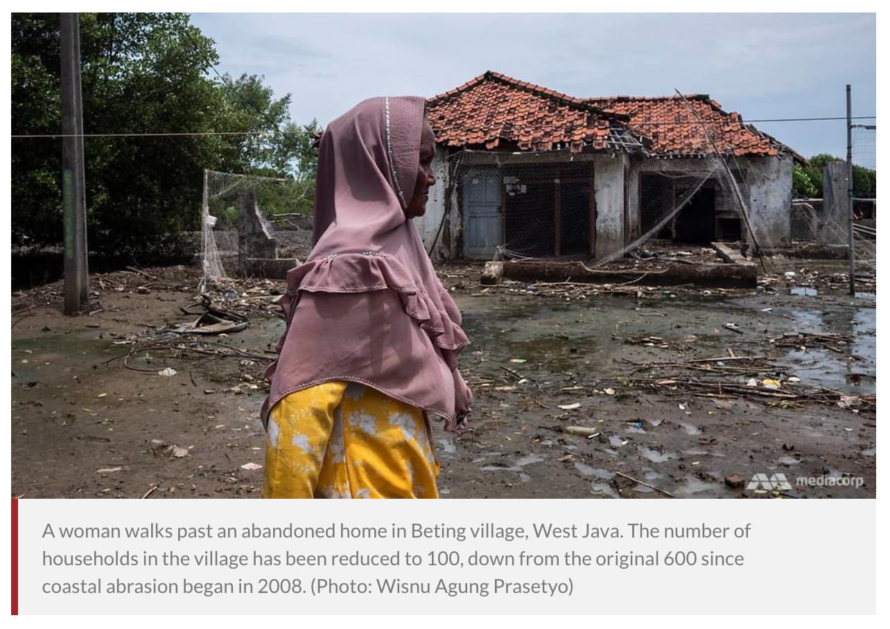 A woman walking past an abandoned home in Beting village, West Java